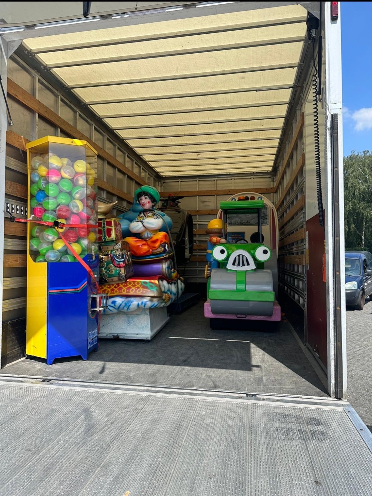 Vrachtwagen geladen met kiddy rides en een capsuleautomaat